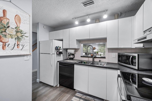 kitchen featuring sink, stainless steel appliances, a textured ceiling, and white cabinetry