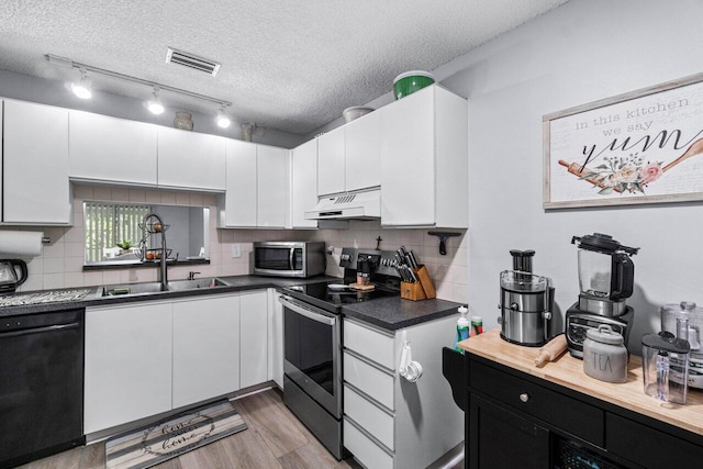 kitchen featuring a textured ceiling, appliances with stainless steel finishes, light hardwood / wood-style floors, and white cabinetry