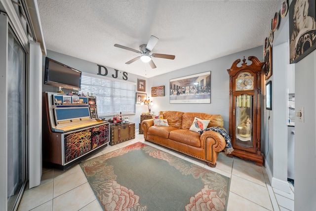 living room featuring light tile patterned flooring, a textured ceiling, and ceiling fan