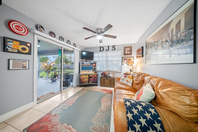 living room featuring a textured ceiling, ceiling fan, and light tile patterned floors