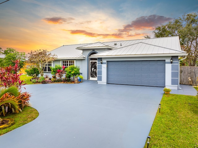 single story home featuring a yard and a garage