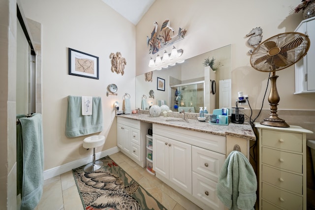 bathroom with tile patterned flooring, vaulted ceiling, walk in shower, and vanity