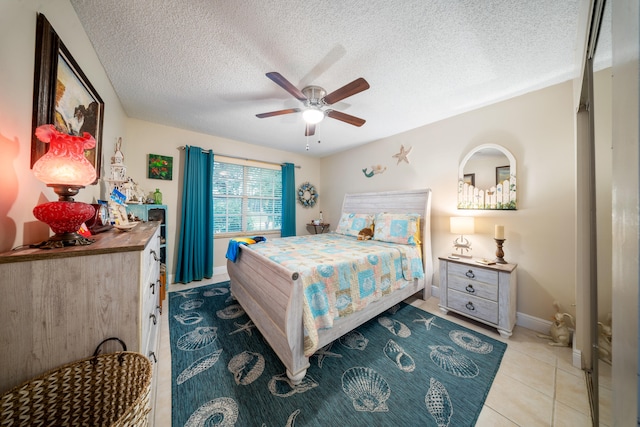 bedroom with a textured ceiling, ceiling fan, and light tile patterned floors