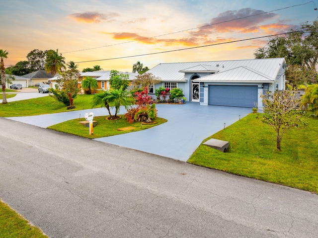 ranch-style home featuring a yard and a garage