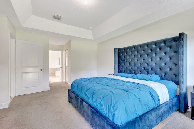 carpeted bedroom featuring a tray ceiling and a textured ceiling