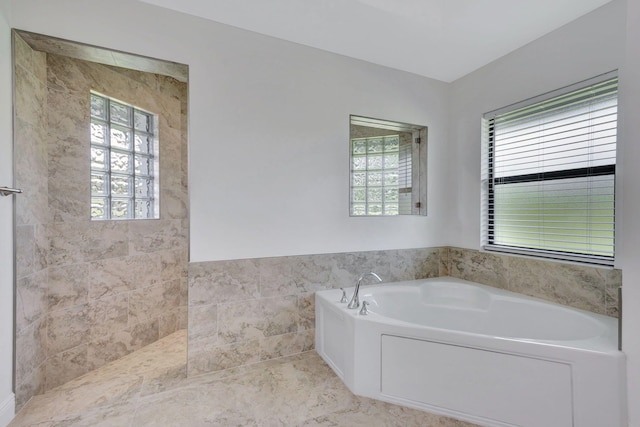 bathroom with a washtub and tile walls