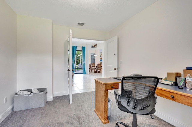 carpeted office space featuring a textured ceiling