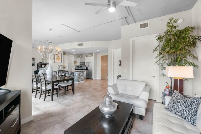 living room featuring ceiling fan with notable chandelier