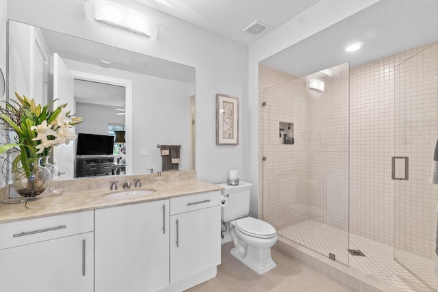 bathroom with tile patterned flooring, vanity, toilet, and a shower with shower door