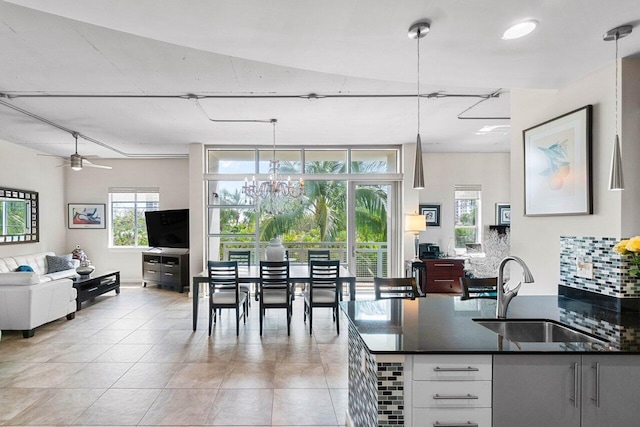 kitchen featuring white cabinets, tasteful backsplash, hanging light fixtures, and sink