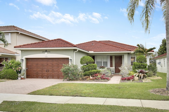 view of front of home featuring decorative driveway, stucco siding, a garage, a tiled roof, and a front lawn