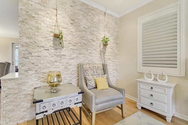 sitting room with baseboards, light wood-style floors, and crown molding