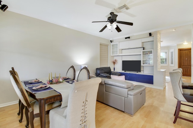 dining area featuring light wood-style floors, ceiling fan, visible vents, and crown molding