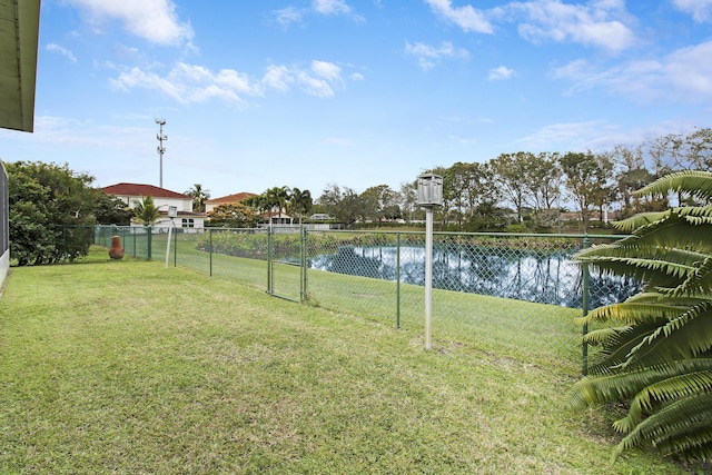 view of yard featuring a water view and fence