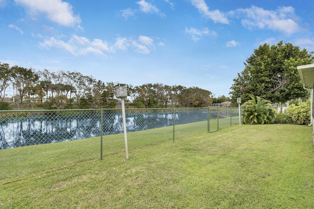 view of yard with a water view and fence