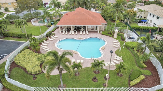 community pool featuring a yard, a residential view, a patio area, and fence