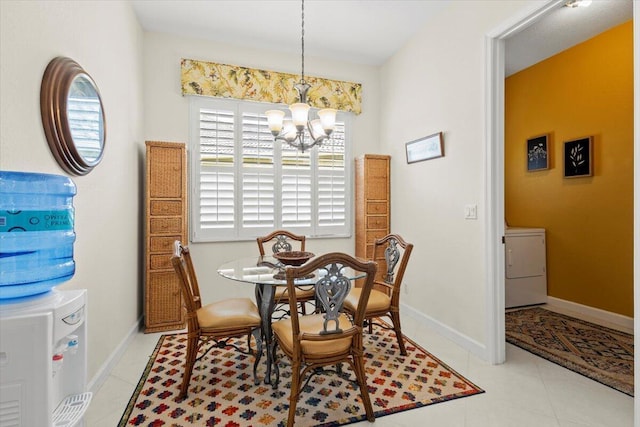 dining area featuring washer / clothes dryer, light tile patterned floors, and an inviting chandelier