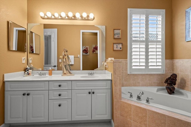 bathroom featuring vanity and a relaxing tiled tub