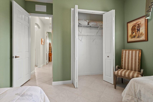 bedroom with light tile patterned floors and a closet