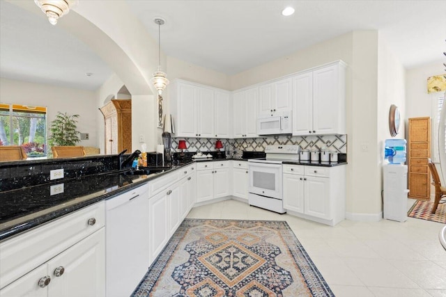 kitchen with white cabinets, white appliances, decorative light fixtures, and dark stone countertops