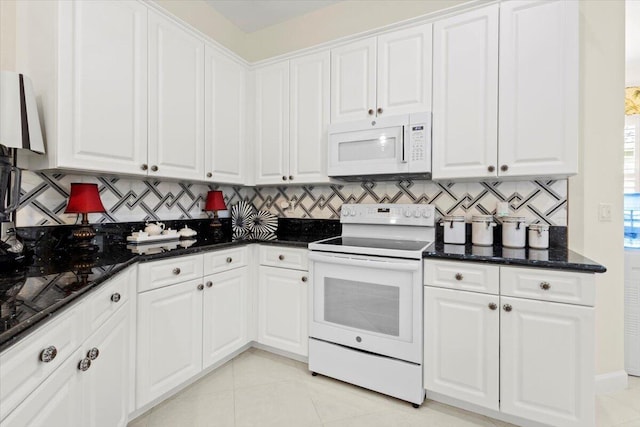 kitchen with decorative backsplash, range with electric stovetop, dark stone countertops, light tile patterned floors, and white cabinetry