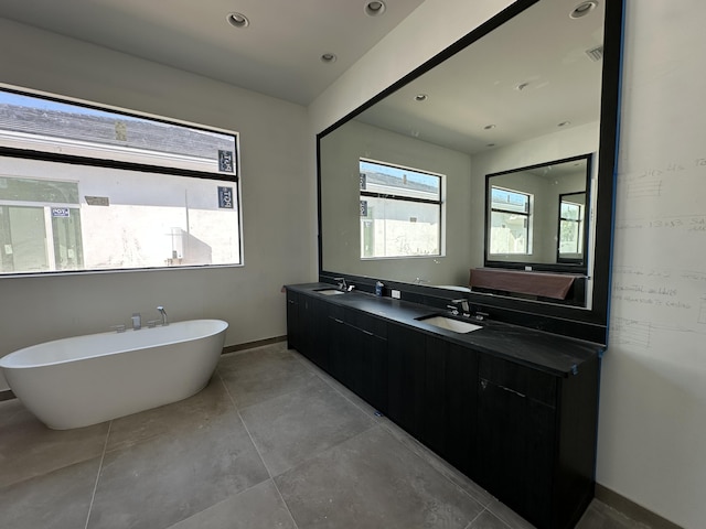 bathroom featuring double vanity, a soaking tub, recessed lighting, and a sink