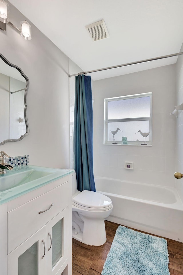 full bathroom featuring wood-type flooring, vanity, toilet, and shower / bath combo with shower curtain