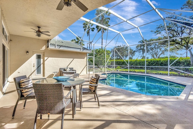 view of pool featuring glass enclosure, ceiling fan, and a patio