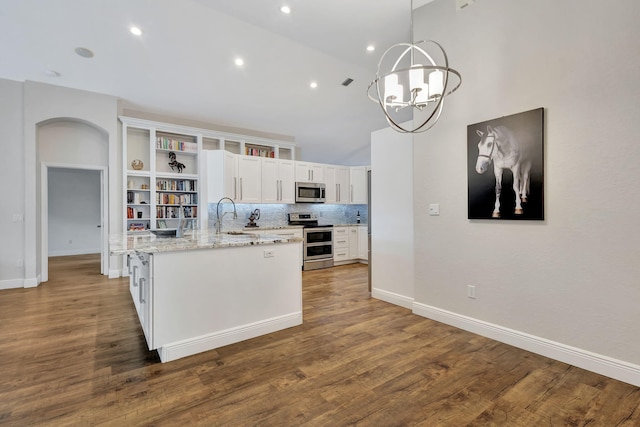 kitchen featuring light stone countertops, appliances with stainless steel finishes, pendant lighting, an inviting chandelier, and white cabinetry