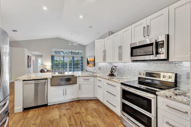 kitchen with white cabinetry, ceiling fan, kitchen peninsula, lofted ceiling, and appliances with stainless steel finishes