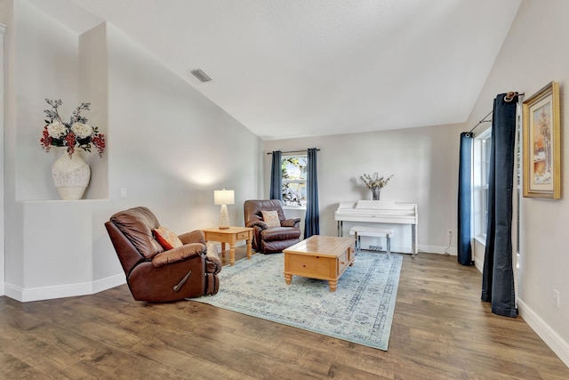 living room with vaulted ceiling and hardwood / wood-style flooring