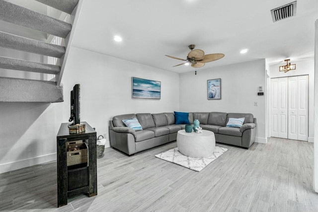 living room featuring light hardwood / wood-style flooring and ceiling fan