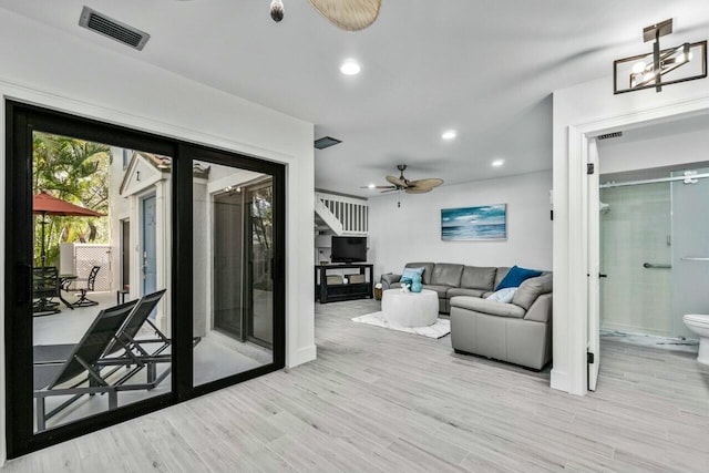 living room with light wood-type flooring and ceiling fan