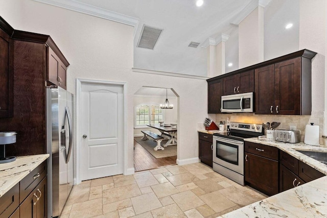 kitchen with decorative light fixtures, light stone counters, dark brown cabinetry, stainless steel appliances, and a chandelier