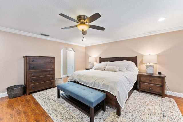 bedroom featuring hardwood / wood-style floors, ceiling fan, and ornamental molding