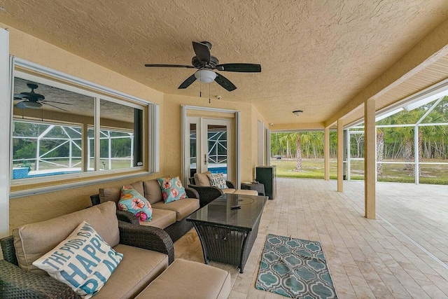 view of patio / terrace featuring an outdoor hangout area, glass enclosure, and ceiling fan