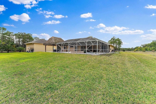 back of house featuring a yard and glass enclosure