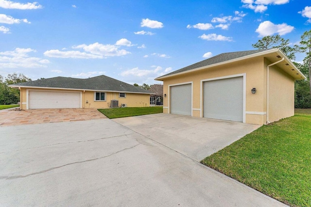 view of front facade featuring central AC unit, a garage, and a front lawn