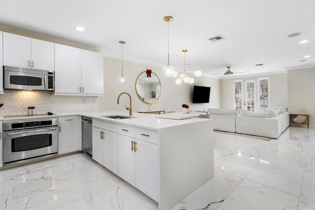 kitchen featuring ceiling fan, sink, pendant lighting, white cabinets, and appliances with stainless steel finishes