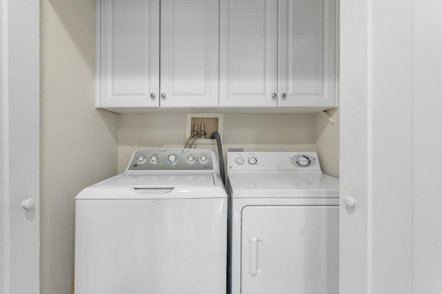 washroom with cabinets and washer and dryer