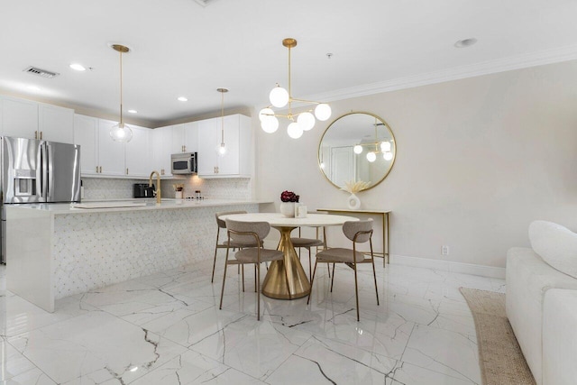 dining room featuring a notable chandelier, crown molding, and sink