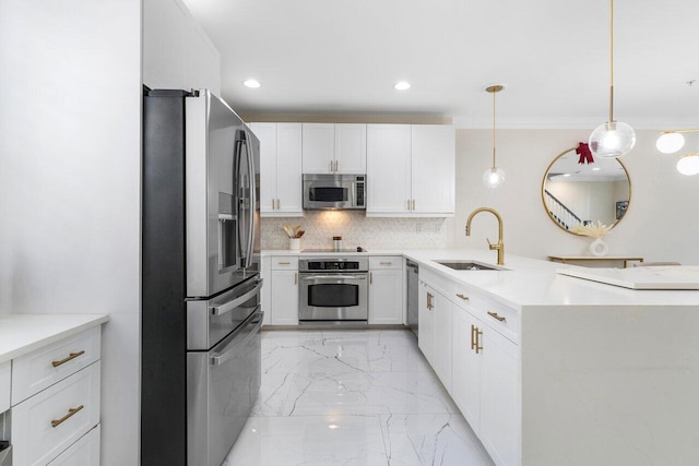 kitchen with pendant lighting, white cabinets, sink, and stainless steel appliances