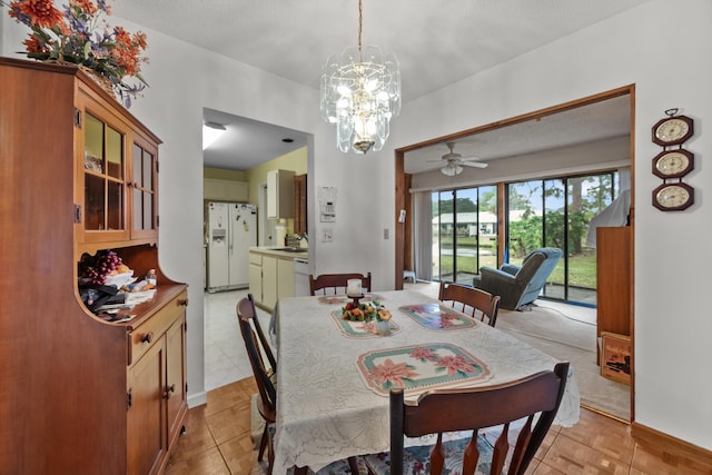 tiled dining room with sink, an inviting chandelier, and a textured ceiling