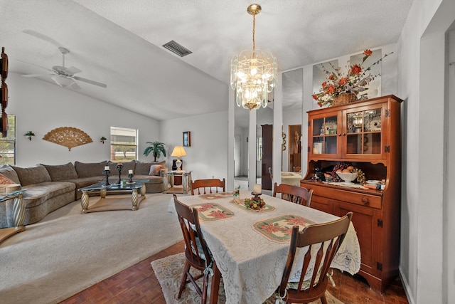 dining space featuring ceiling fan with notable chandelier, a textured ceiling, dark parquet flooring, and lofted ceiling