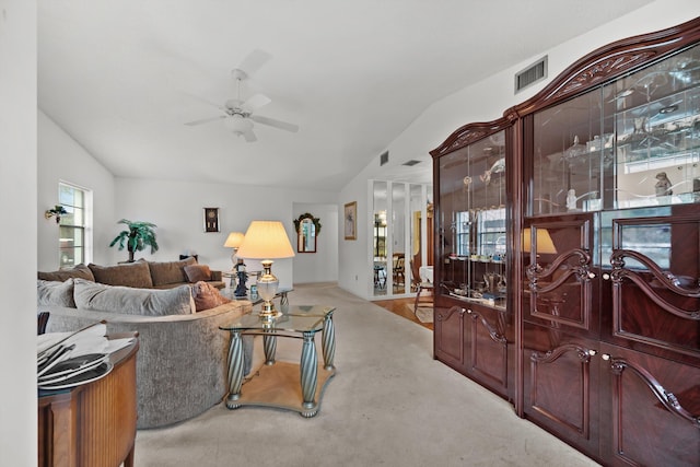 carpeted living room with ceiling fan and lofted ceiling