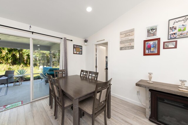 dining area with lofted ceiling and light wood-type flooring