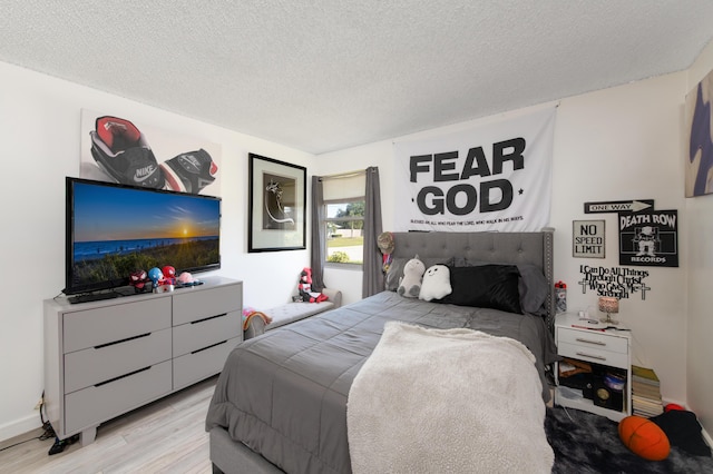 bedroom featuring a textured ceiling and light hardwood / wood-style floors