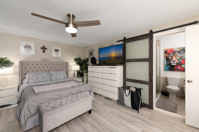 bedroom with ensuite bath, ceiling fan, and a textured ceiling