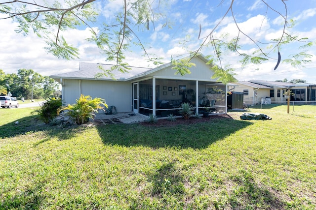 rear view of property featuring a sunroom and a yard