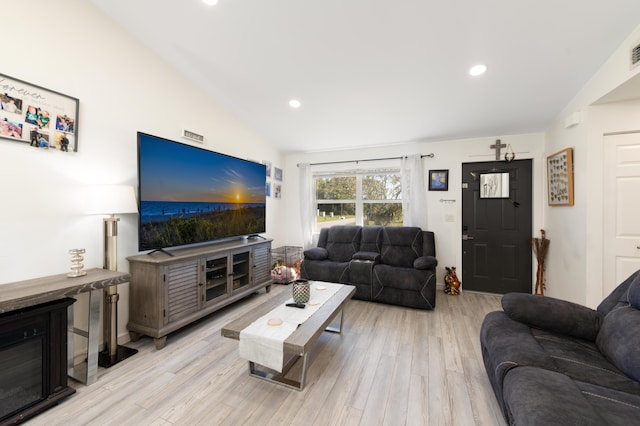 living room featuring light hardwood / wood-style floors and vaulted ceiling